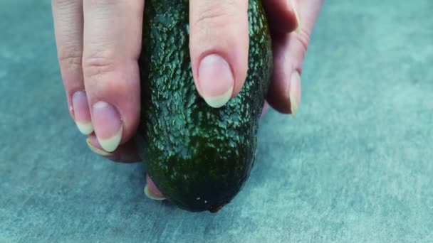 Opening fresh half-avocado. On the gray screen — Stock Video