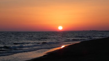 Denizin üzerinde güzel pembe gün batımı, doğal dalgalarla.