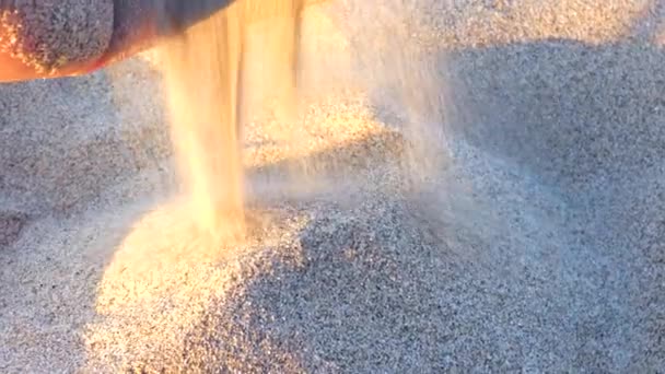 L'homme prend le sable et verse ses doigts contre le sable. Voyage et nostalgie pour de beaux endroits .