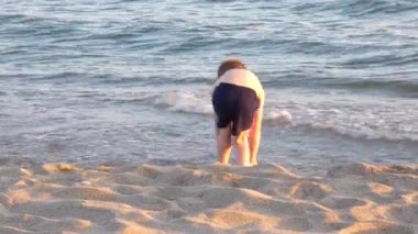 Onu sahilde yürüyen belirlenemeyen bebek ayakları izliyor. Çıplak ayakla sıçrıyor.