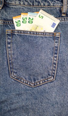 Arka plan kompozisyonu olarak lacivert kot pantolonun arka cebindeki euro banknotları.