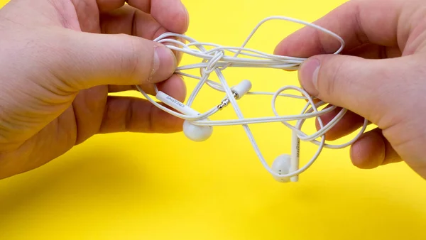 Man Hands Trying Untangle Tangled Headphones Yellow Background Close — Stock Photo, Image