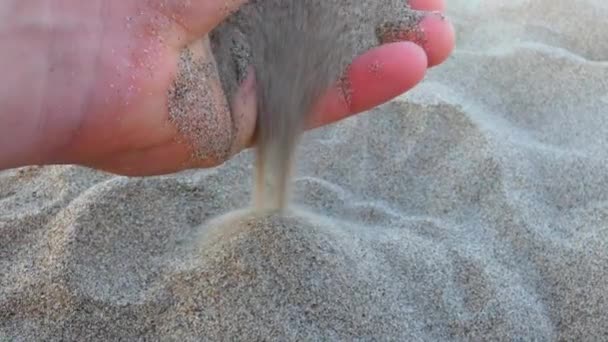 手抓住沙子，无论是在沙漠中还是海滩上，让沙子穿过他的手指。特写镜头 — 图库视频影像