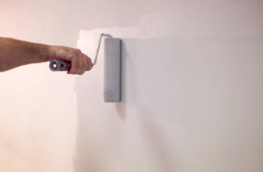 Dekoratörler duvarları silindirle boyuyor..