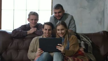 Ellerini sallayarak ve videoda konuşmak neşeli hipsters hatta evde kanepede oturan dijital tablet ile çağırın. Arkadaşlar, tablet PC'de app üzerinden iletişim olumlu gençler yapma video ara