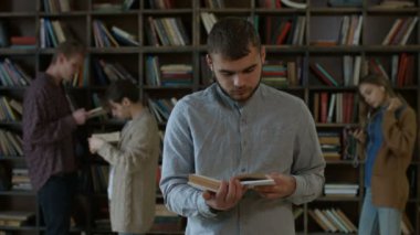 Yakışıklı hipster öğrenci Kitaplığı'nda bir kitap okuma
