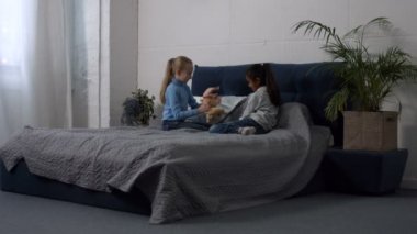 Şirin çok etnik kız oyuncakları yatağa oynarken