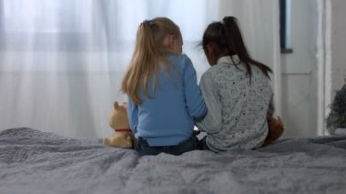 Geri görüntülemek küçük çok etnik kızlar yatakta oturuyor