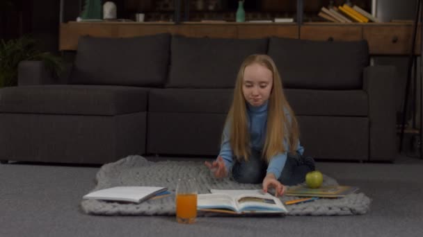 Милая блондинка-школьница делает домашнее задание — стоковое видео