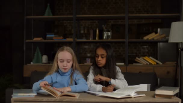 Мультиэтнические школьницы учатся вместе на дому — стоковое видео
