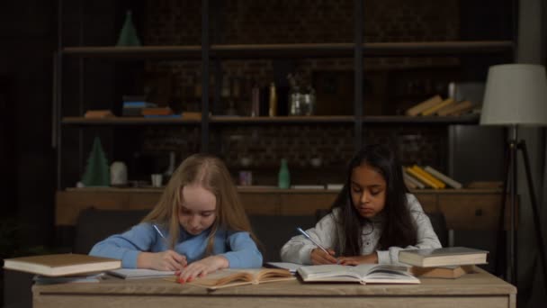 Niñas sonrientes con libros sobre sus cabezas — Vídeos de Stock