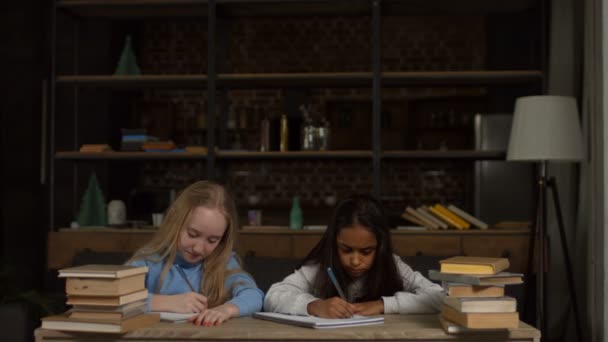 Κουρασμένος σχολείο τα κορίτσια μελετώντας με ένα σωρό βιβλίων — Αρχείο Βίντεο