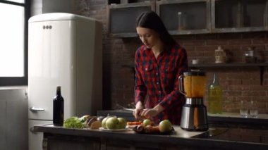 Mutlu kadın koyarak blender içine havuç dilimleri