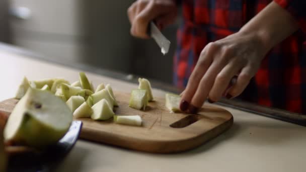 Жіночі руки рубають яблуко на обробній дошці — стокове відео