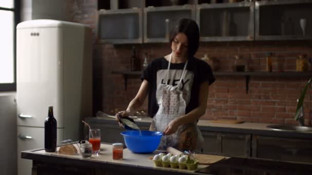 Mujer sonriente mezclando huevos y harina de trigo en un tazón — Vídeo de stock