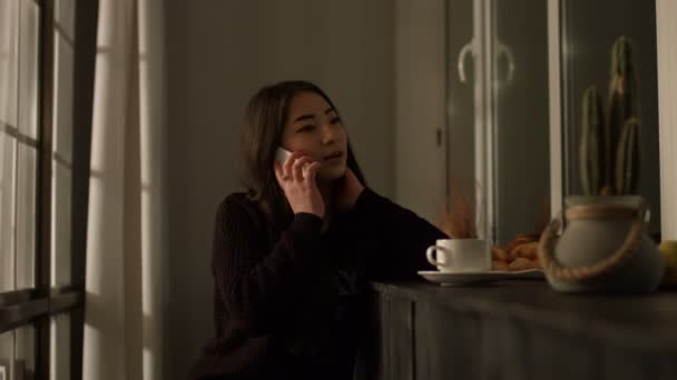 Nádherná Asijské dívka mluví o chytrých telefonu doma — Stock video