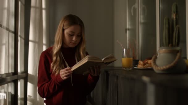 Jeune femme intelligente lisant un livre à la maison — Video