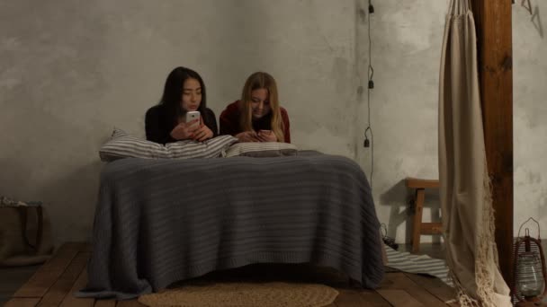 不同的女孩躺在床上用手机发短信 — 图库视频影像