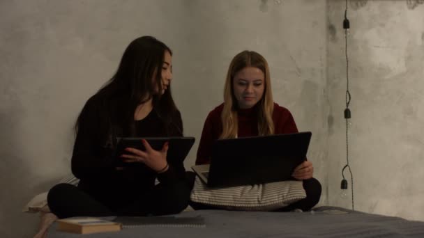 Meninas diversas estudando com dispositivos eletrônicos — Vídeo de Stock
