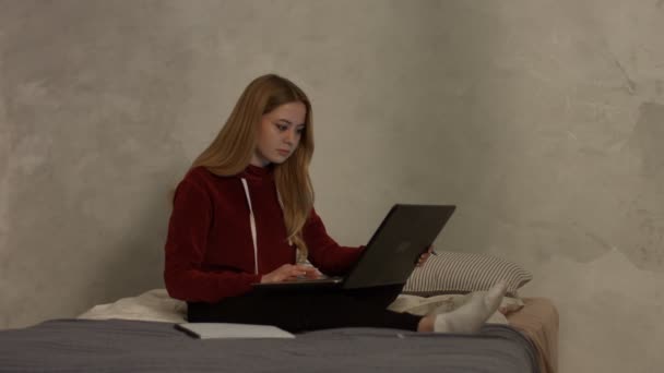 Linda estudiante femenina con portátil estudiando en el dormitorio — Vídeo de stock