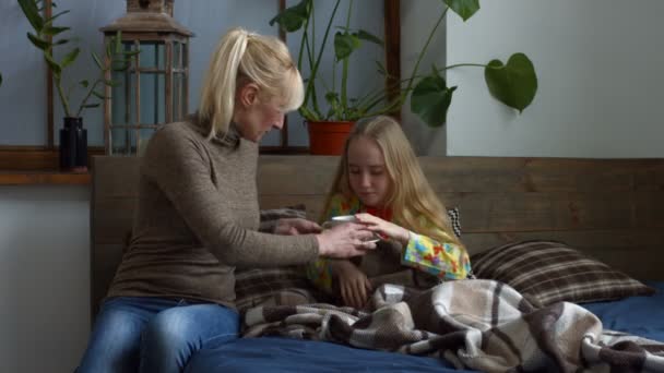 关心母亲给她生病的女儿热茶 — 图库视频影像
