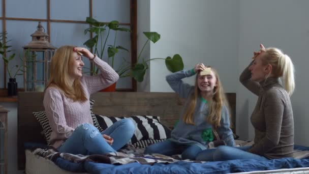 Família excitada jogando adivinhar quem jogo na cama — Vídeo de Stock