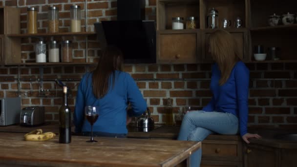 Amigos felizes do sexo feminino gostando de vinho na cozinha — Vídeo de Stock