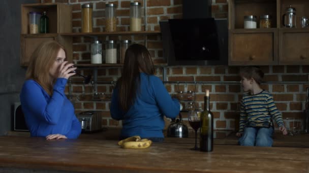 Mujeres alegres charlando sobre el vino tinto en la cocina — Vídeos de Stock