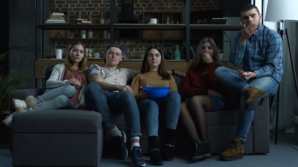 Группа подростков смотрит комедийный фильм с попкорном — стоковое видео