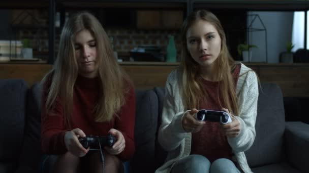 Радостные девушки играют в видеоигры с джойстиками — стоковое видео