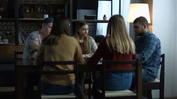 Grupo de amigos felizes jogando jogo de tabuleiro na mesa — Vídeo de Stock