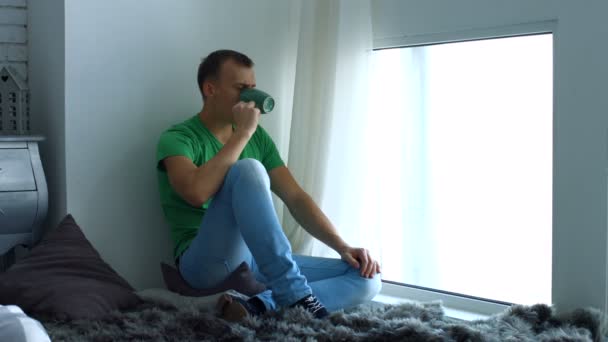 Hombre bebiendo café y admira la vista desde la ventana — Vídeos de Stock