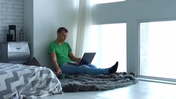 Knappe mannelijke freelancer werken thuis via laptop — Stockvideo