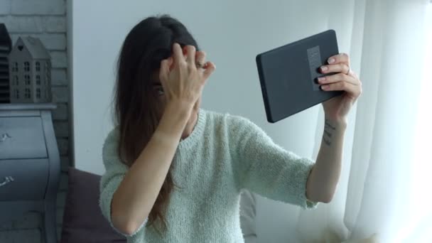 Γυναίκα, προσαρμόζοντας τα μαλλιά χρησιμοποιώντας tablet ως καθρέφτης — Αρχείο Βίντεο