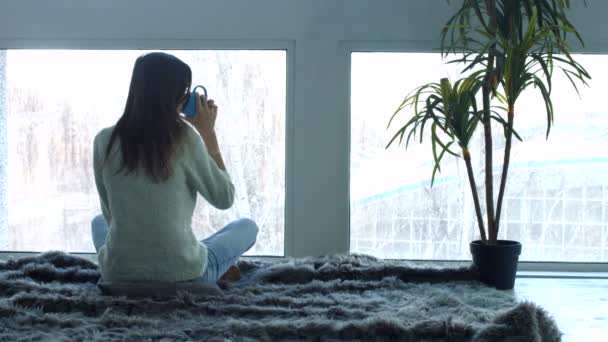 Молодая женщина наслаждается чашкой кофе в квартире на чердаке — стоковое видео