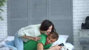Sevgi dolu kadın erkeğini evde yatakta kucaklayan