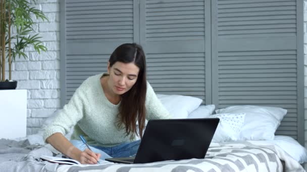 Mulher freelance com laptop trabalhando na cama em casa — Vídeo de Stock