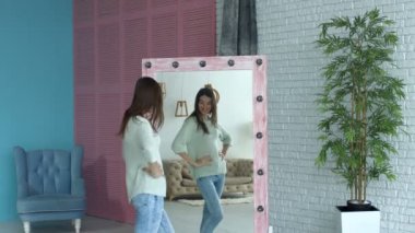Neşeli kadın onun vücut şekli aynasından kontrol