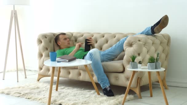 Homme détendu surfant sur tablette numérique à la maison — Video