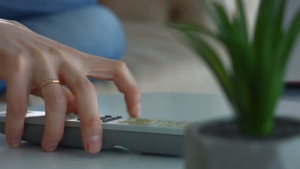 Mãos femininas segurando tv controle remoto em casa — Vídeo de Stock