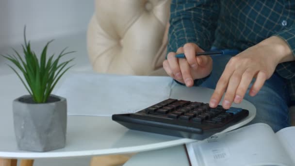 Hembra manos haciendo cálculos en la calculadora — Vídeos de Stock