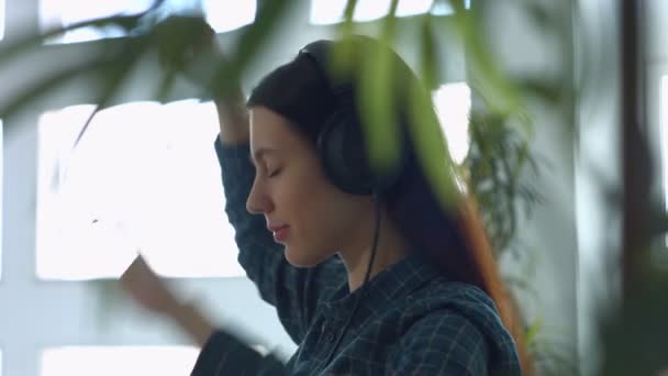 Mujer alegre disfrutando de la música en los auriculares en casa — Vídeos de Stock