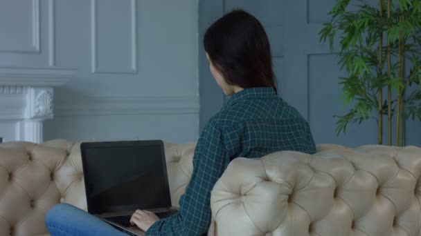 Charmante vrouw netwerken op laptop thuis — Stockvideo