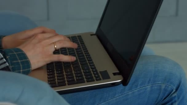 Kobiece dłonie, wpisując na klawiaturze laptopa w domu — Wideo stockowe