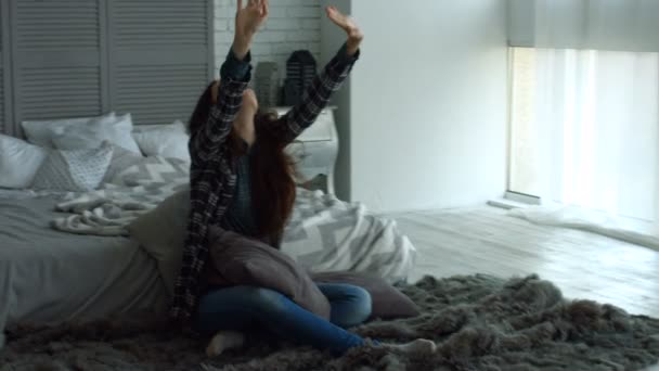 Positive Frau streckt ihre Arme im Schlafzimmer aus — Stockvideo