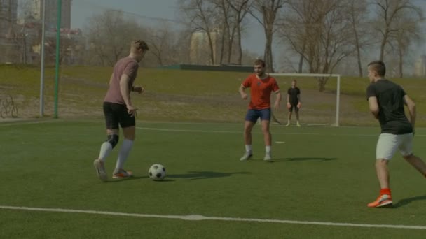 Молодые футболисты в действии на спортивной площадке — стоковое видео