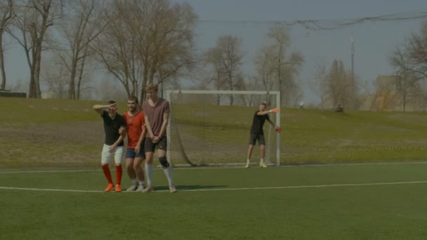 Футболист получает прямой свободный удар во время игры — стоковое видео