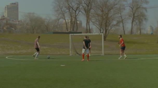 Fröhliche Teenager spielen Fußball auf Sportplatz — Stockvideo