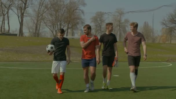 Jugadores de fútbol dejando el campo de fútbol después del partido — Vídeos de Stock