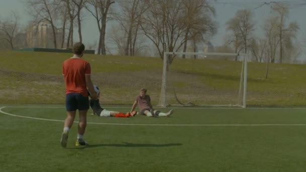 Футболисты отдыхают на футбольном поле после игры — стоковое видео